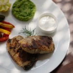 Plated grilled chicken dish with sides