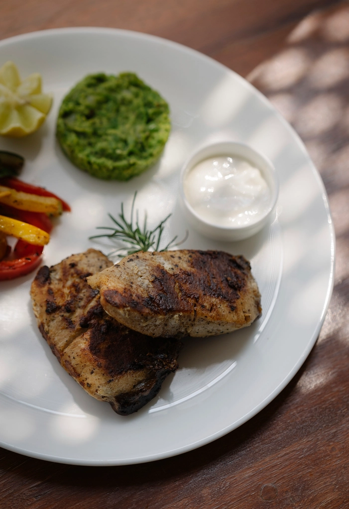Plated grilled chicken dish with sides