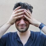 Person with a headache holding their forehead