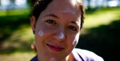 Person applying sunscreen to their face