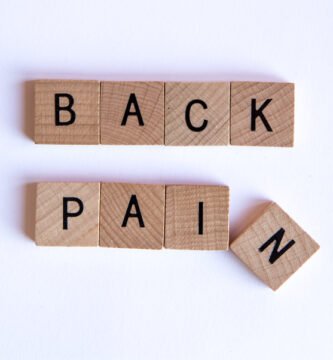 Person holding lower back due to back pain