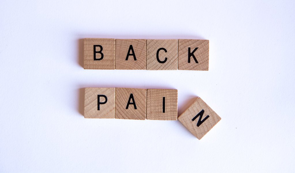 Person holding lower back due to back pain