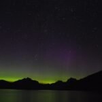 Green and violet northern lights glowing across the night sky