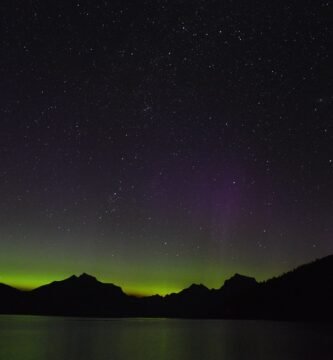 Green and violet northern lights glowing across the night sky