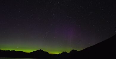 Green and violet northern lights glowing across the night sky