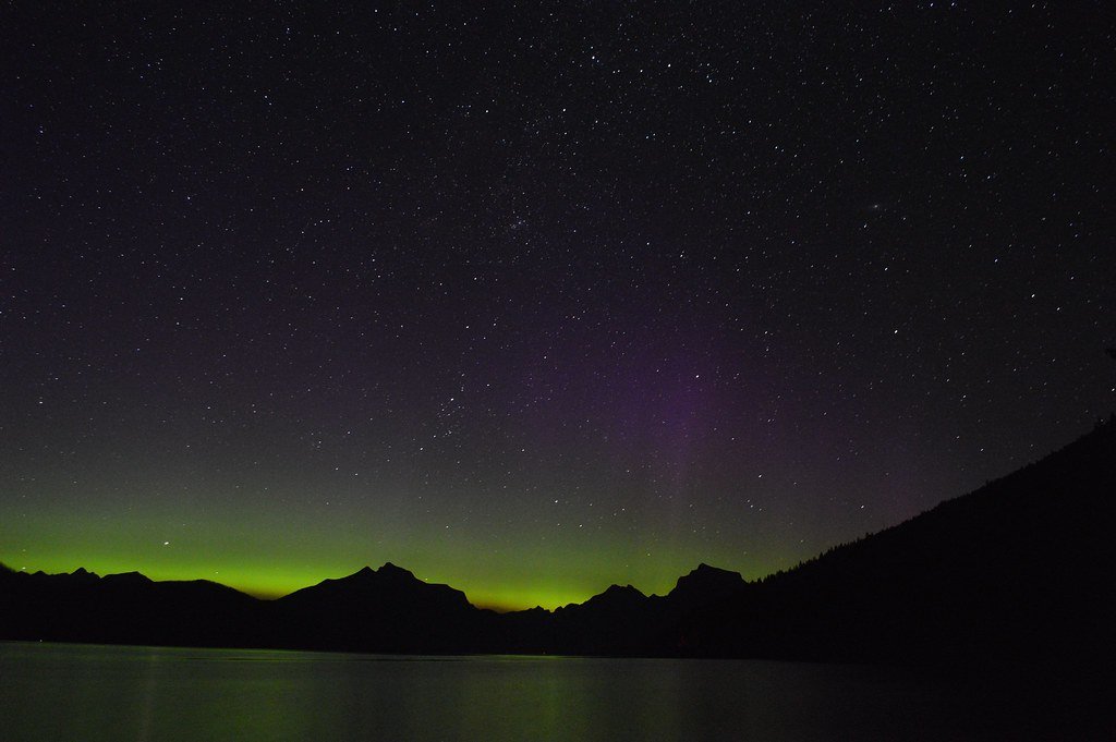 Green and violet northern lights glowing across the night sky