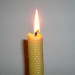 Lit wax candle in a home setting
